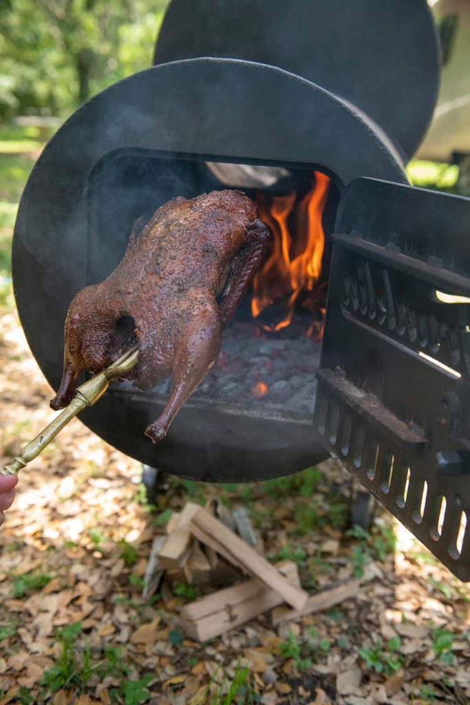 Franklin Barbecue Pits with Duck being "crisped" over the coals/flame.